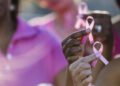 Multiracial hands holding breast cancer awareness ribbon